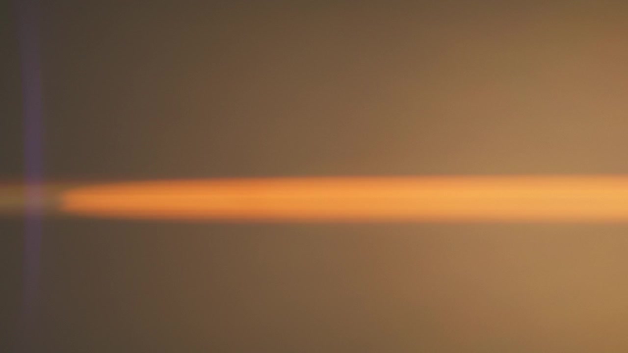 Flickering anamorphic lens flares against dark background
