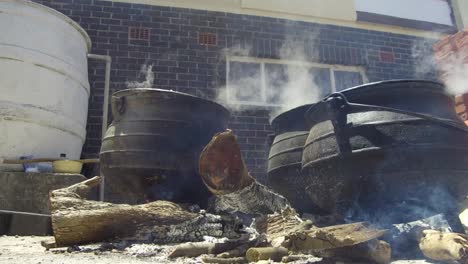 three cast iron potjie pots on the fire