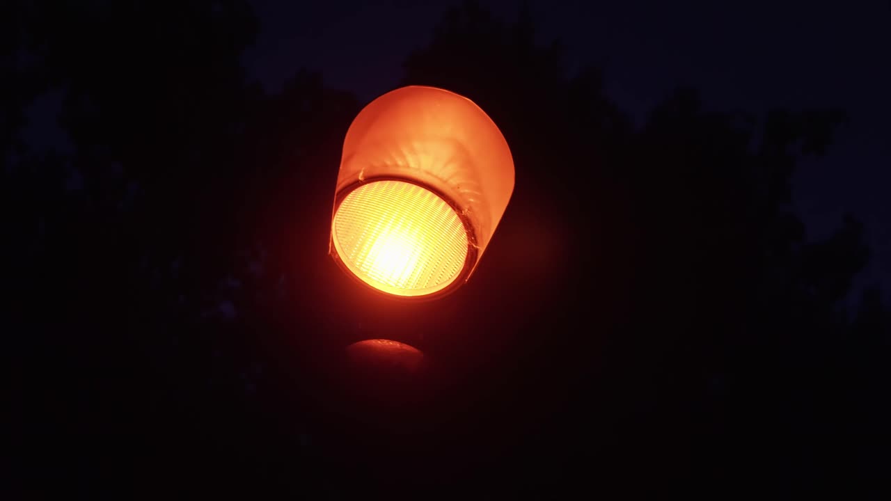 Close up of red traffic light at night, cinematic smooth shot