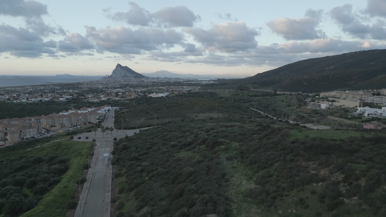 Drone 4K in ascesa all'alba dalla Spagna, che guarda verso Gibilterra all'orizzonte con alcune nuvole