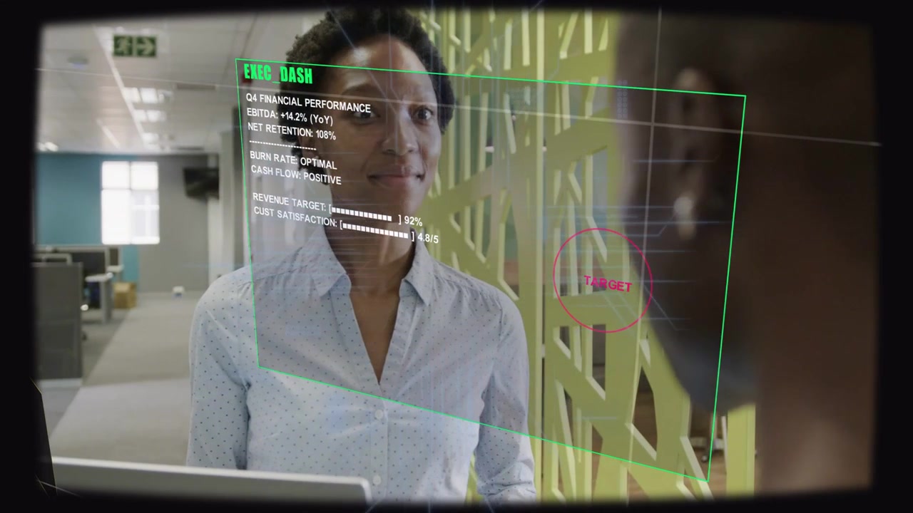 Mid-career businesswoman reading EXEC DASH HUD appearing on laptop, confirming metrics and nodding