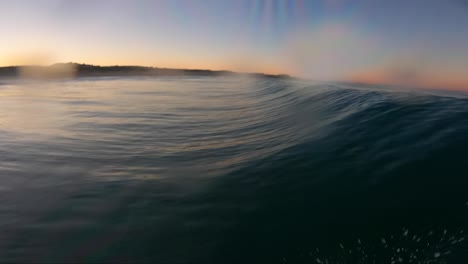 surfeando una ola haciendo un flotador con una go pro en la boca en un fantástico amanecer en cascais, portugal