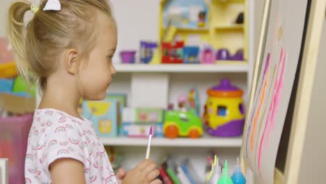 Little-girl-having-fun-painting-with-water-colors