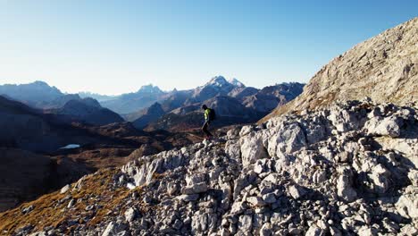 excursionista caminando cuesta abajo en los dolomitas en otoño