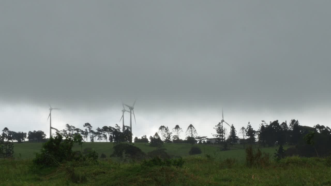 폭풍우 치는 날씨에 녹색 농지, 넓은 정적 샷이 있는 풍력 터빈