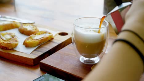 Woman-pouring-coffee-in-the-cup-at-cafe-4k