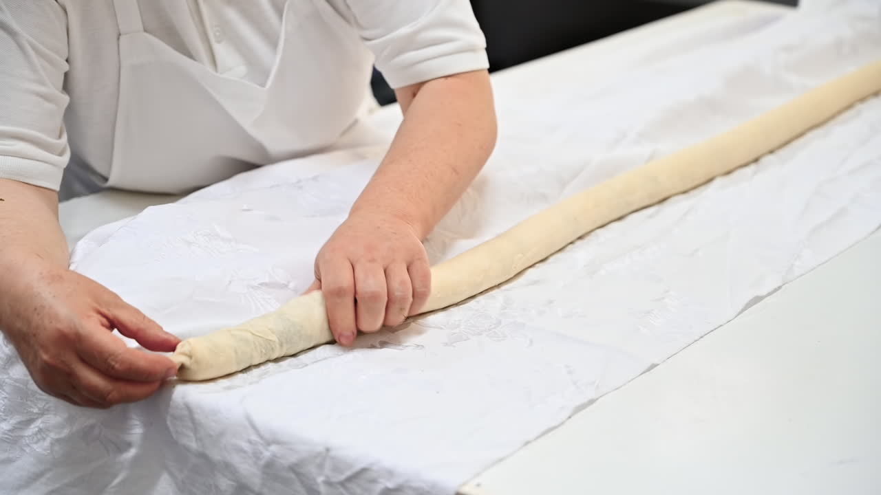 Cook working with rolled dough with filling for placints, Romanian and Moldovan traditional food. Slow motion
