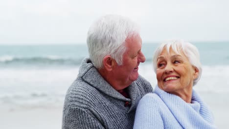 Senior-couple-embracing-each-other-on-the-beach