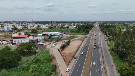 serene view of a village surrounded by lush vegetation and highway under an expansive sky.