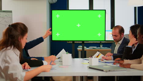grupo de personas de negocios discutiendo el plan de la compañía con una pantalla verde de televisión de maqueta