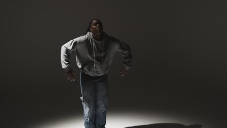 full length studio portrait shot of young woman dancing in spotlight 2