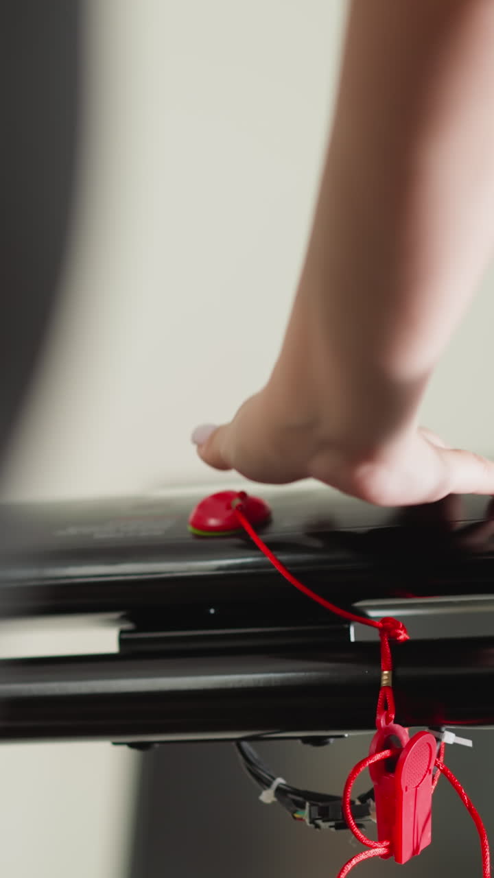 트레드밀 컨트롤 패널의 설정을 조정하는 여인: 단호한 여성은 운동 기기의 속도를 증가시켜 스포츠 클럽에서 달리기에 참여합니다.