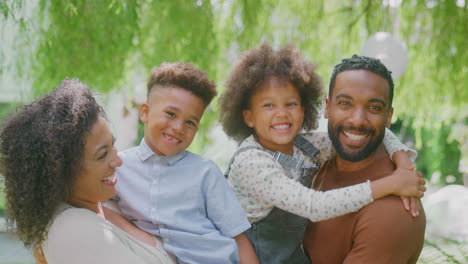 portrait of smiling family at home outdoors in garden together