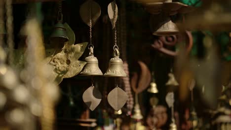 prayer bells for sale in a nepal market, gold metal prayer bells in a shop at a temple at bhaktapur ancient city