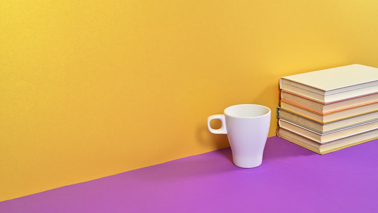 una pila de libros antiguos de tapa dura y una taza de café aparecen en el tema dorado púrpura.