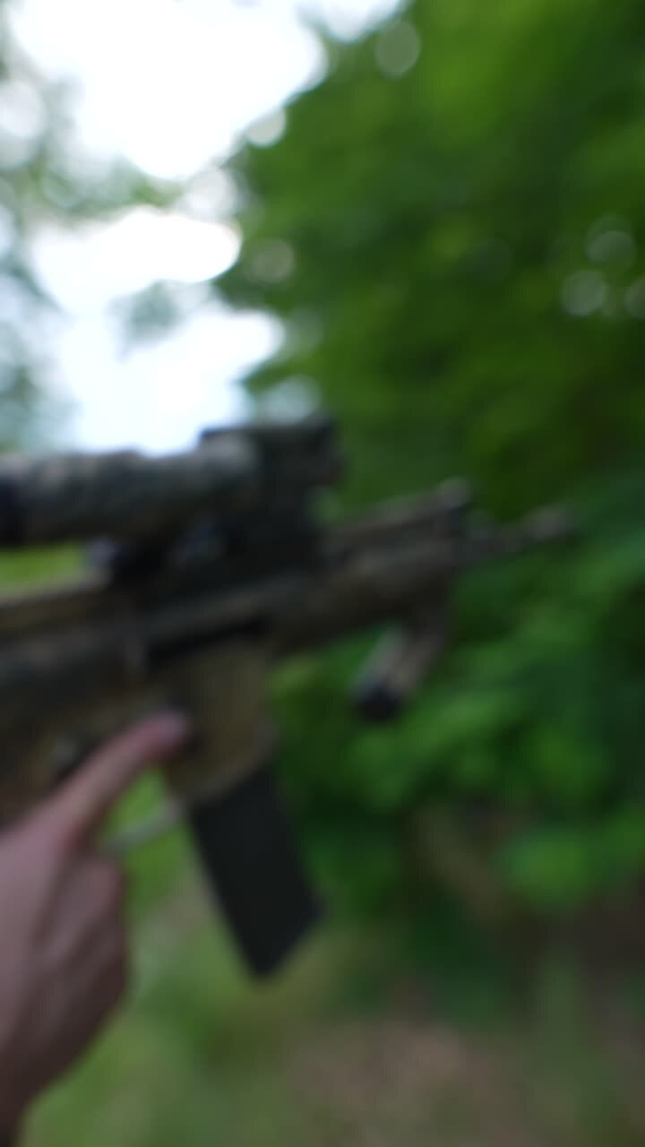 Military Personnel with Weapon in Woodland Environment