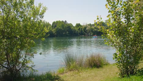 beautiful scenery of a lake surrounded with green forest on a sunny day