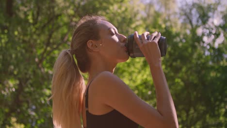 woman hydrating in a park