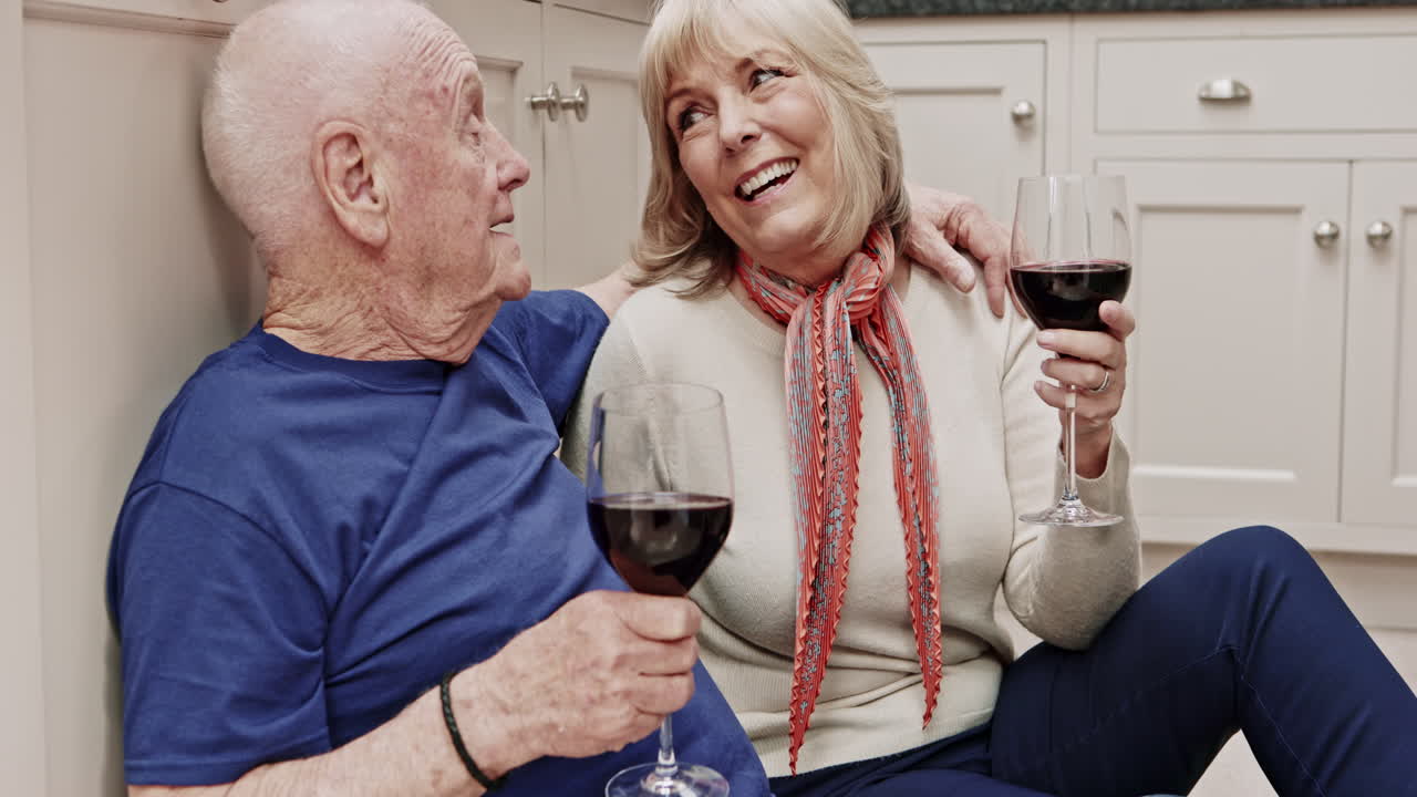 Elderly couple enjoying wine at home
