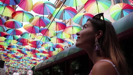 girl looking up at colored umbrellas in awe slow motion