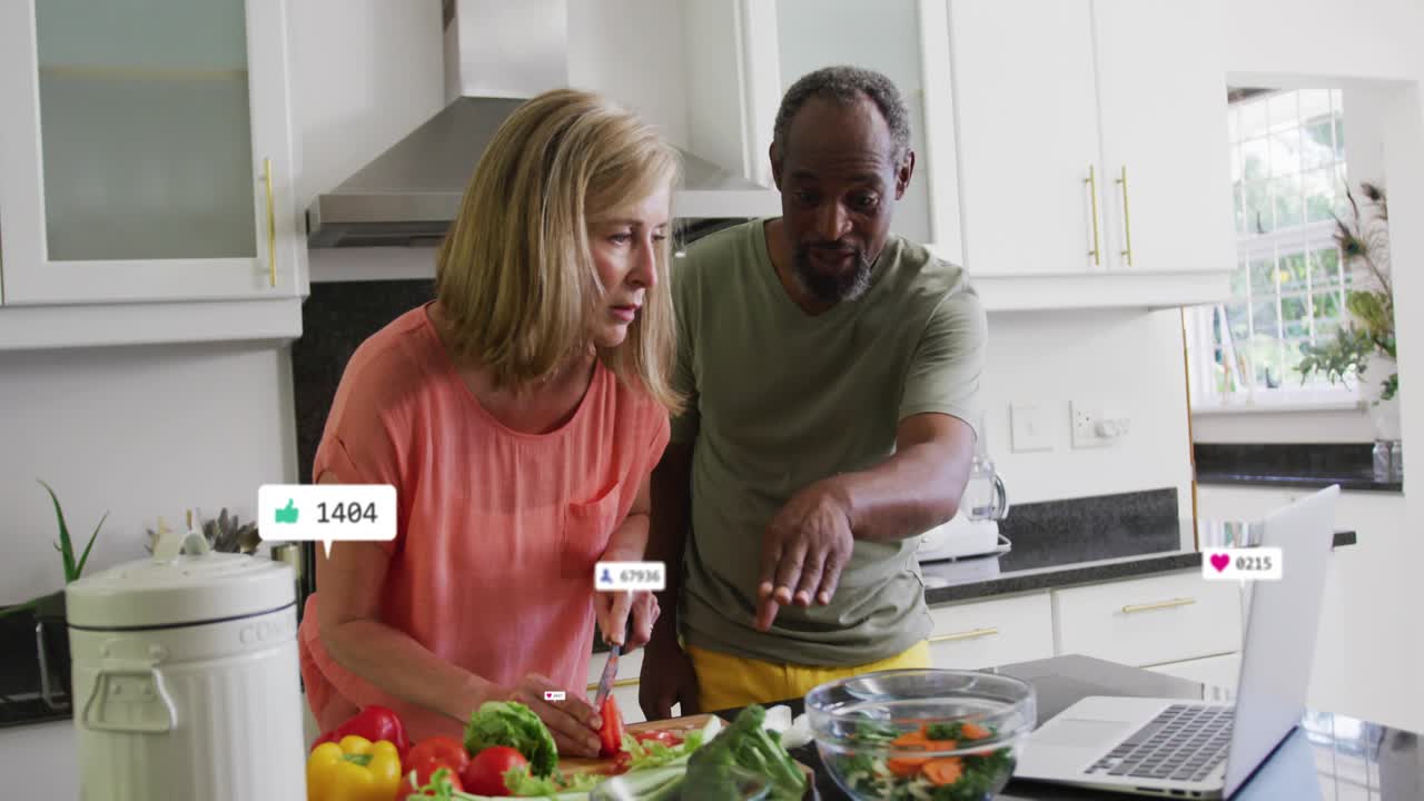 Woman prepping salad in kitchen while man tapping laptop seeing animated marketing metrics changing