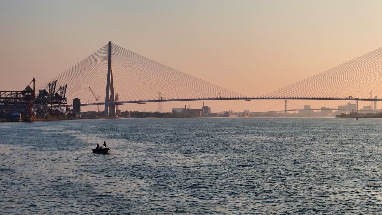Scenic view of Gordie Howe International Bridge at dusk over calm Detroit river