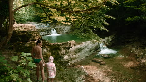 familie genießt einen wasserfall im wald