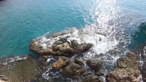 wide pan shot looking down the cliffs on the coastline of turkey, beautiful turquoise water and bright sunny day