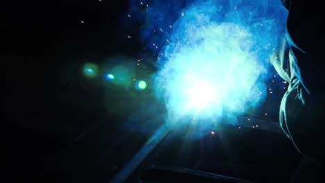 stream of bright sparks from industrial metal cutting. blue flame and sparks