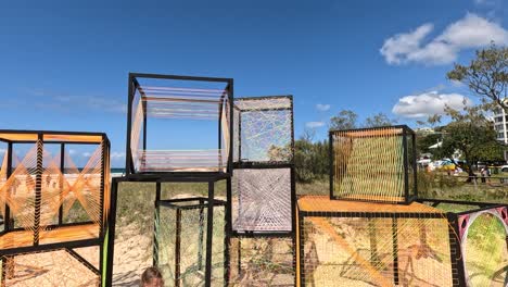 colorful net cubes displayed on sandy beach