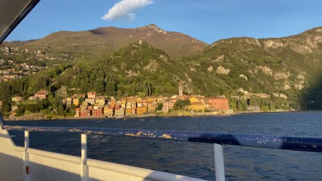 view from touristic cruising boat of varenna italian village illuminated by sunset light
