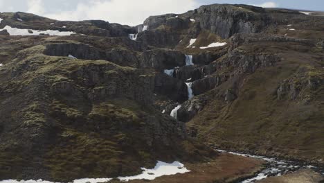 Klifbrekkufossar-Waterfall-cascading-rocky-snowy-mountains-in-Iceland