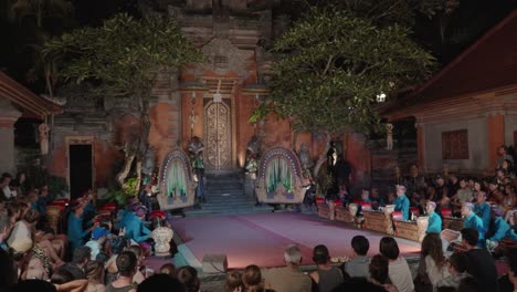 night view of ubud palace in bali during legong show start, tourists sitted listen to musicians play on gangsa metallophones around the court