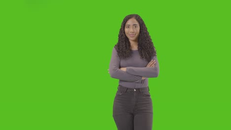three quarter length studio portrait of woman against green screen smiling at camera 2
