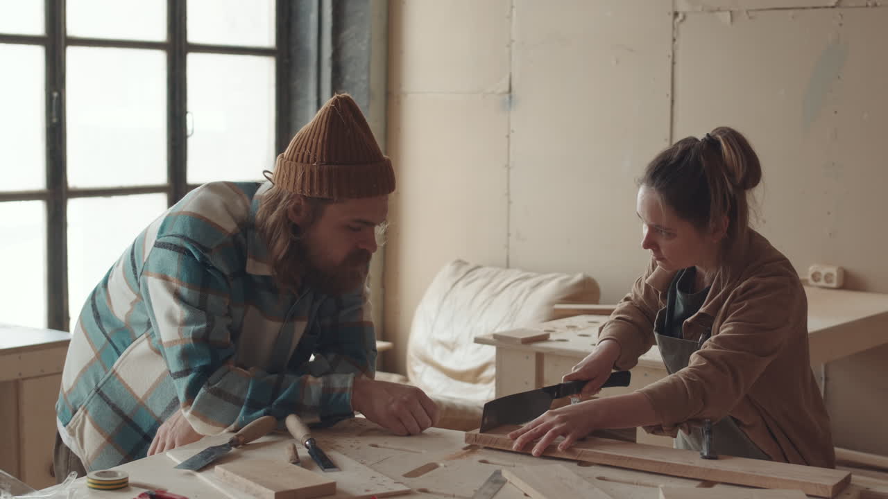 Male and Female Joiners Working in Carpentry Workshop