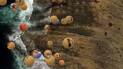 Digital-composition-of-multiple-face-emojis-floating-against-aerial-view-of-the-sea-waves