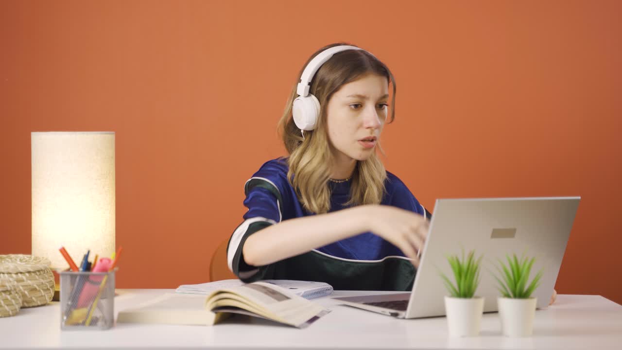 Young woman closing laptop with angry expression.