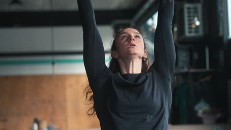 mujer pelirroja haciendo dedos de los pies a la barra de ejercicio de entrenamiento intenso motivación en el gimnasio crossfit