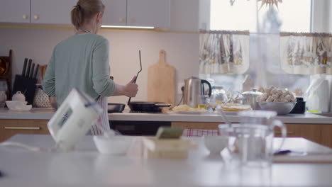 positive happy woman cook and dance in kitchen