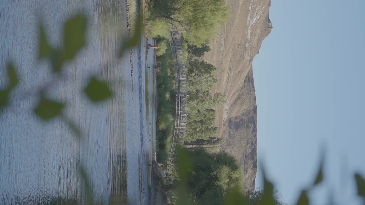 зеленые холмы и мост через реку в патагонии, аргентина