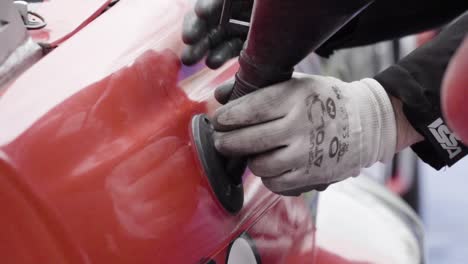 pouring fuel gas into the tank of race car from fuel pot by two men mechanics in slow motion-1