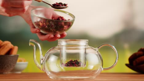 preparing rose tea in a glass teapot