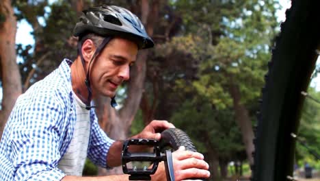 hombre comprobando los neumáticos de su bicicleta