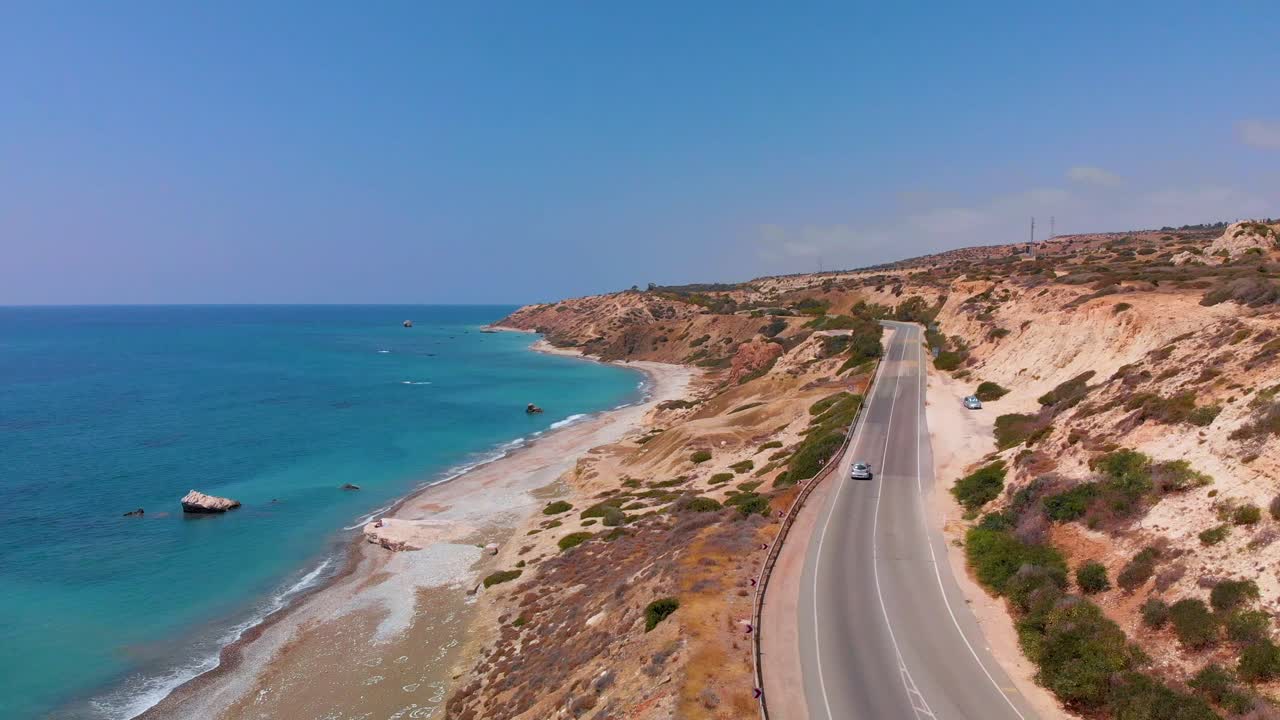 vista aérea volando sobre una carretera cerca de la playa y la costa del mar mediterráneo en paphos chipre