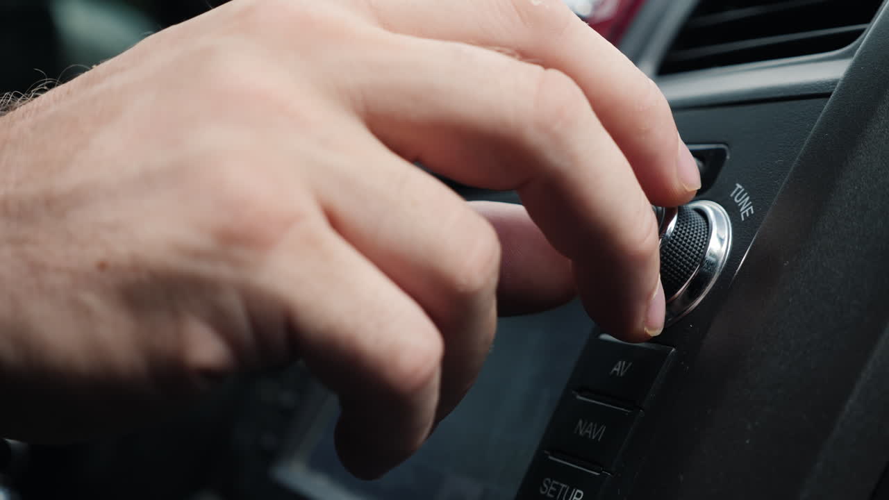 mano masculina ajusta la afinación de la toma de primer plano de la radio del coche