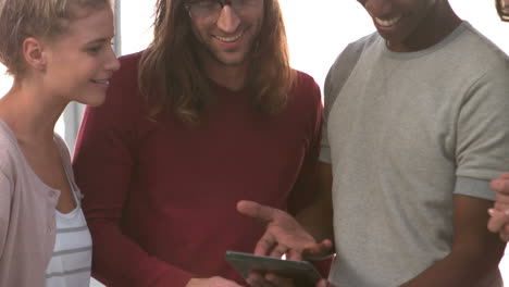 happy hipsters laughing and watching a tablet