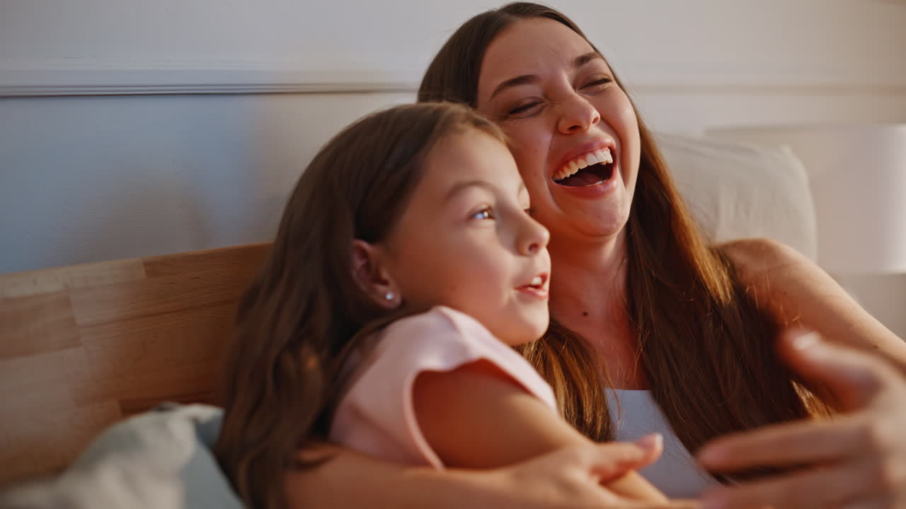 Cute child mom hugging at modern room closeup. Girl bonding to young mother