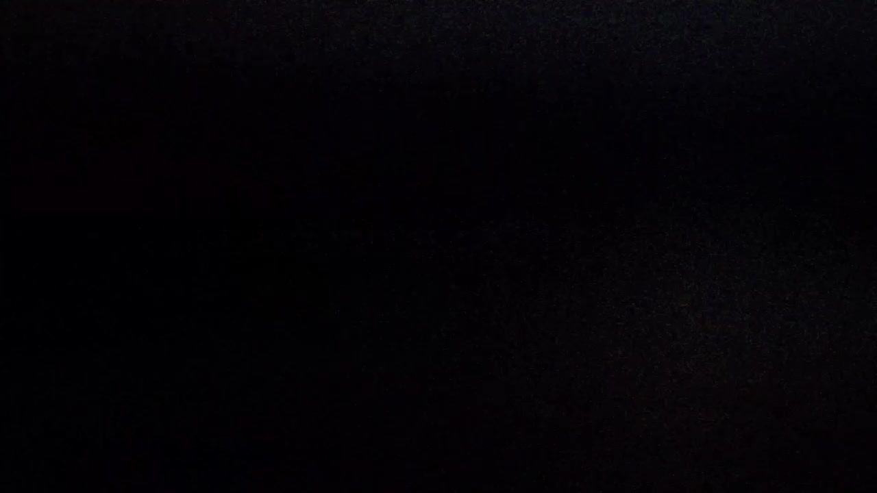Authentic vhs tape noise with subtle static and glitches on a dark, faded screen. Perfect overlay for creating a retro 80s or 90s look
