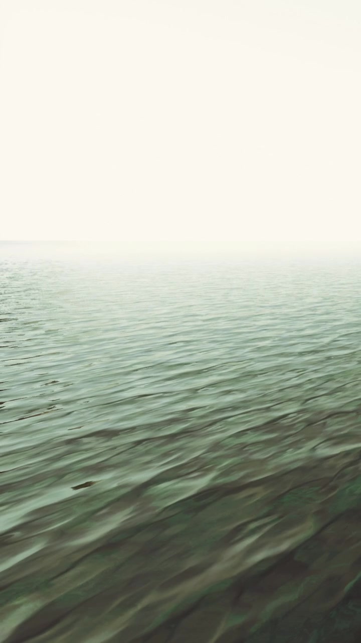 Waves on a calm water surface at dawn near the shoreline