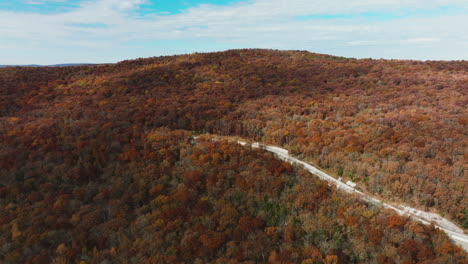 mountain road and lush autumn forest in arkansas, usa - aerial drone shot